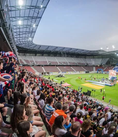 Nighttime ceremony at United World Games with fireworks and a cheering crowd in a large stadium.