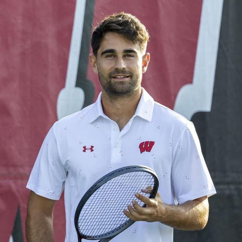 Gabriel Huber – University of Wisconsin-Madison, NCAA DI Headshot of a young male tennis player from the University of Wisconsin holding a tennis racket.