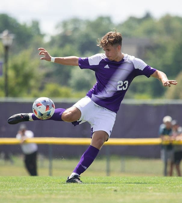 Benedikt Zechmeister – College-Fußballer | Smarthlete College-Fußballer Benedikt Zechmeister schießt einen Ball auf einem Fußballfeld.